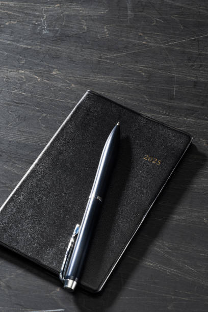 istock 2025 Notebook and pen on wooden table (2025 schedule book) 2175218827