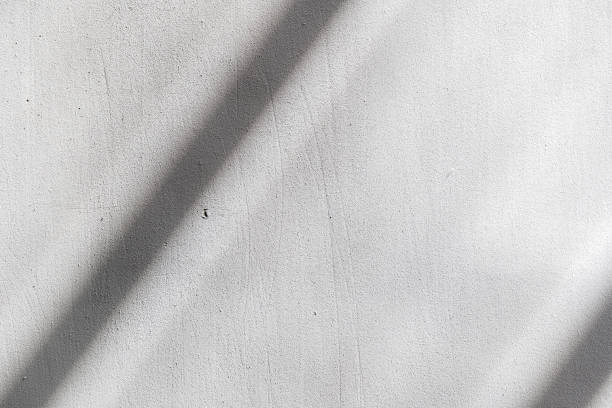 istock Simple white concrete wall with a dark sunlight shadow line, minimal background, front view, frontal shot, nobody. New modern style light grey urban city wall interior exterior backgrounds concept 2175228335