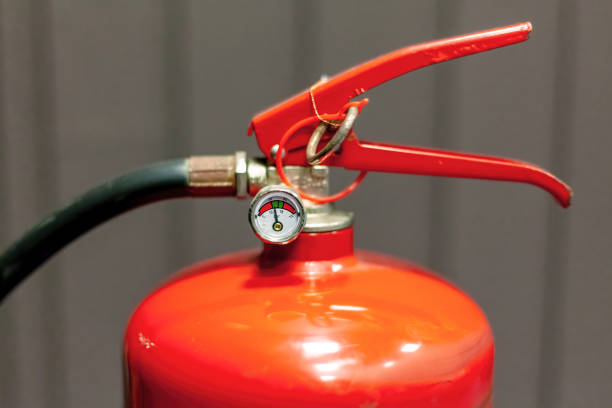istock Classic red fire extinguisher handle and pressure dial gauge meter, safety pin, object top valve detail, extreme object detail extreme closeup, nobody. Repair, service maintenance abstract concept 2175228487