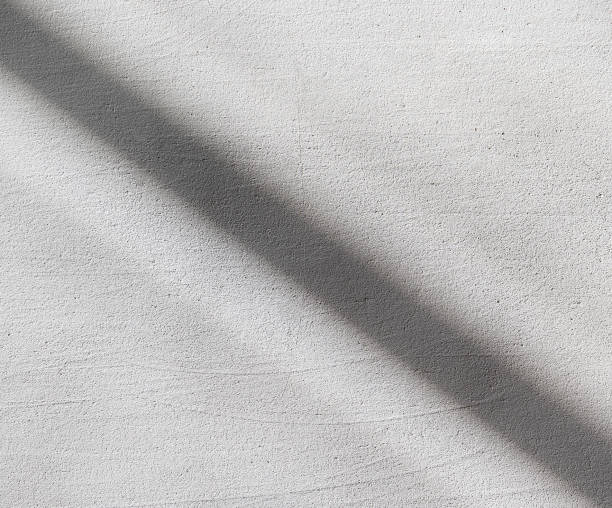 istock Simple white concrete wall with a dark sunlight shadow line in the middle, minimal square background, front view, frontal shot, nobody. New modern style light grey urban city wall interior exterior 2175230587