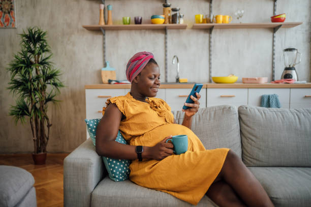 istock Pregnant woman drinking coffee and using phone 2175236155