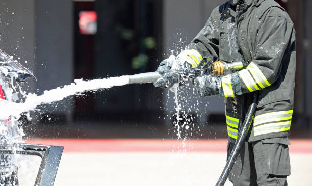 istock firefighter using a hose to spray foam on a fire during an urban emergency 2175239619