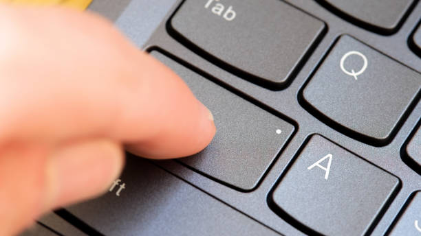 istock Man pressing the Capslock key on a modern laptop computer keyboard, capital letters simple concept, finger pressing the CapsLk key up close detail. Online arguments, shouting in text abstract symbol 2175239778