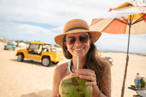 istock Woman drinking coconut water on the beach 2175248939