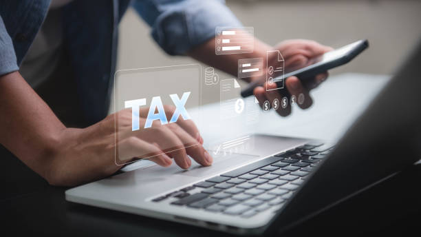 istock Tax Filing Online concept, hands using a laptop and smartphone with digital tax documents, symbolizing the process of online tax filing and management. 2175253737