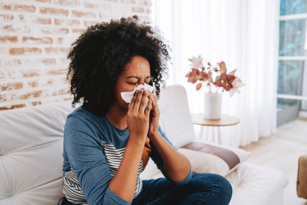 istock Woman sneezing with a tissue on her nose 2175259393