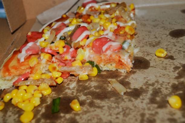 leftover pizza slices topped with sausage, cheese and corn.