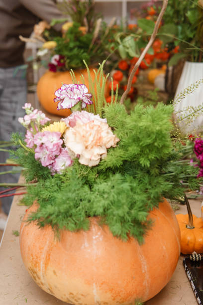 istock Flower arrangement in a pumpkin, autumn interior decor. Creating handmade autumn decor. 2175268593