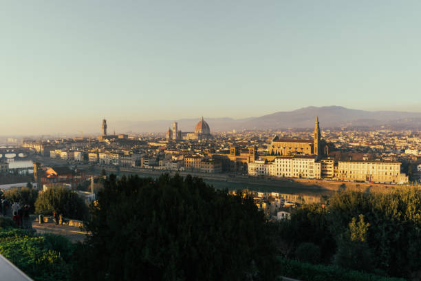 A panoramic view of Florence taken from Piazzale Michelangelo, showcasing the city’s iconic skyline, including the Florence Cathedral and the Arno River. The image captures the beautiful landscape and architectural highlights of Florence during the day.