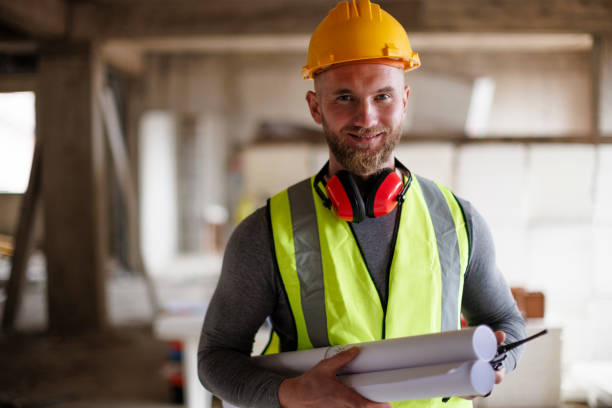 istock Portrait of a confident construction worker holding a blueprint at construction site 2175282444