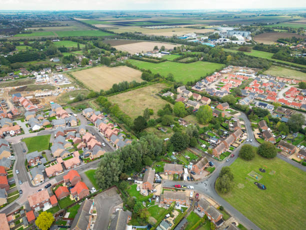 istock Aerial view of two sprawling new housing developments seen between a parcel of land. 2175283739