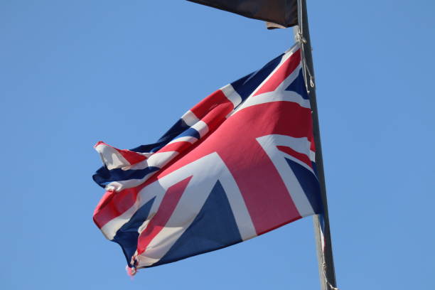 istock Great britain flag against clean blue sky 2175283740