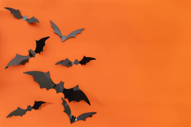 istock Halloween background - Black  bats on bright orange background. Halloween atmosphere. 2175284630