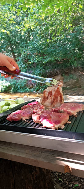 istock A man's hand turns meat on an electric grill with a fork. 2175291290