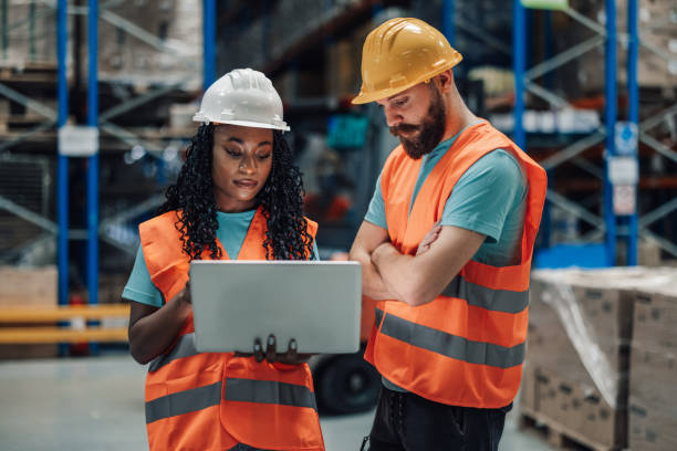 istock Two multiracial workers concentrating on a laptop in a storage facility 2175291777
