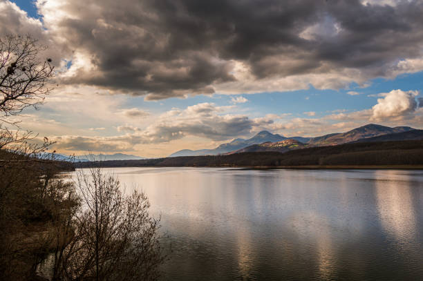 nature sceneries around the lake pertusillo coastline with a cloudy sky in the background
