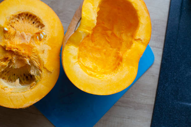 istock Eating self-grown vegetables. Cooking bright orange pumpkin lying on a purple cutting board. 2175295793