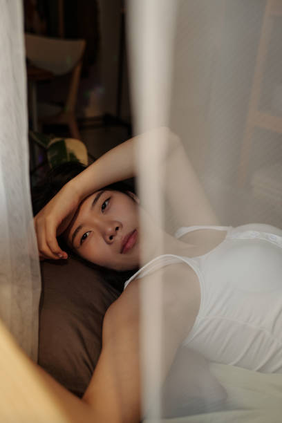 istock Woman with hangover resting on bed 2175300249