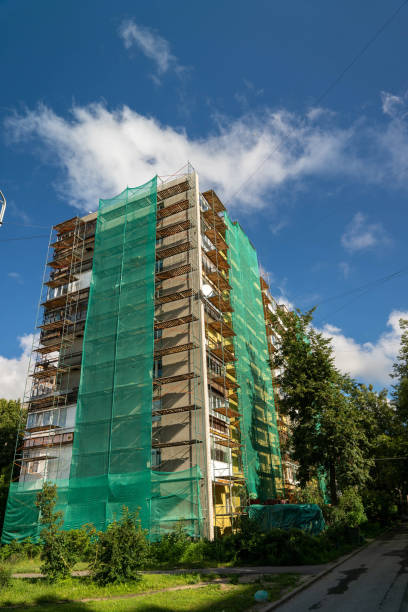 istock A tall building is under renovation with green netting covering its sides 2175307539