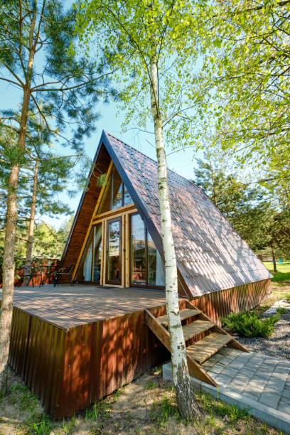 istock A-frame cabin with wooden deck surrounded by trees in a serene natural setting on a sunny day 2175307815