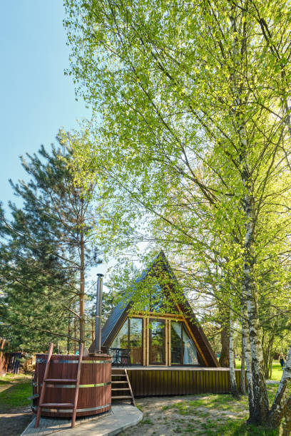 istock Cozy triangular cabin nestled among lush trees in a peaceful outdoor setting during sunny daylight 2175307818