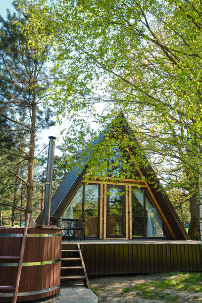 istock Cozy A-frame cabin surrounded by lush greenery with a hot tub in a tranquil forest setting 2175307822