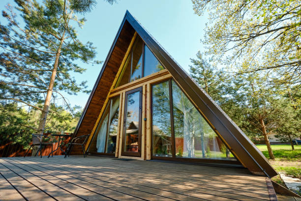 istock Modern A-frame cabin nestled among trees in a serene outdoor setting during sunny daylight 2175307824