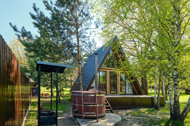 istock Cozy A-frame cabin surrounded by trees with an outdoor hot tub in a serene setting 2175307827