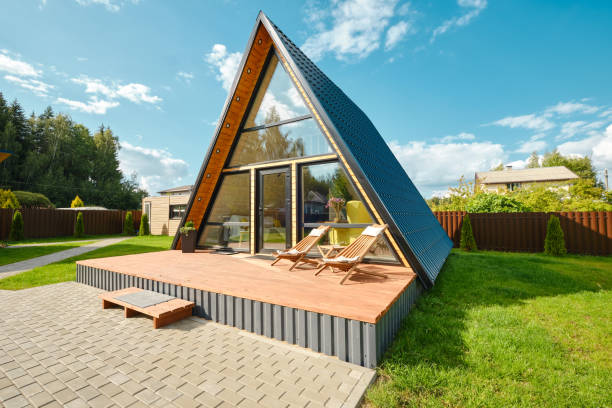 A-frame house with a wooden deck in a tranquil backyard during sunny weather