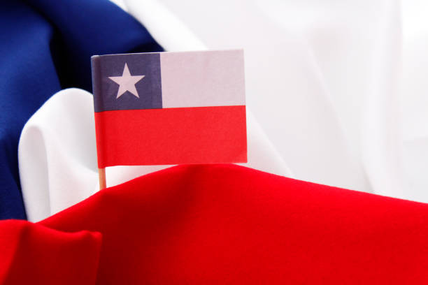 Chilean paper flag on red, white and blue fabric background