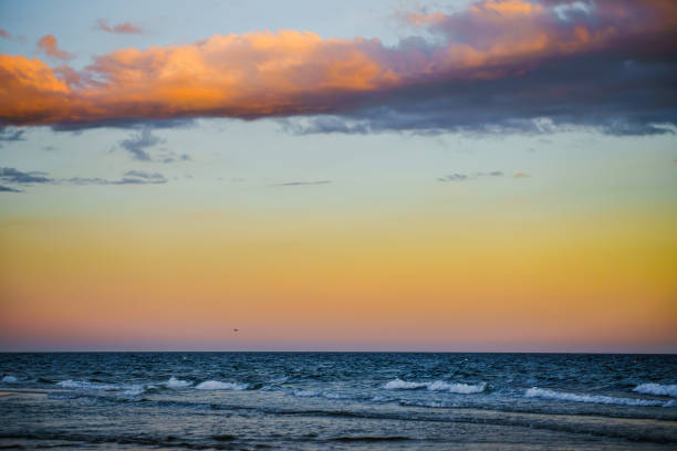 Beautiful gradient sky transitioning from orange to blue above the sea.