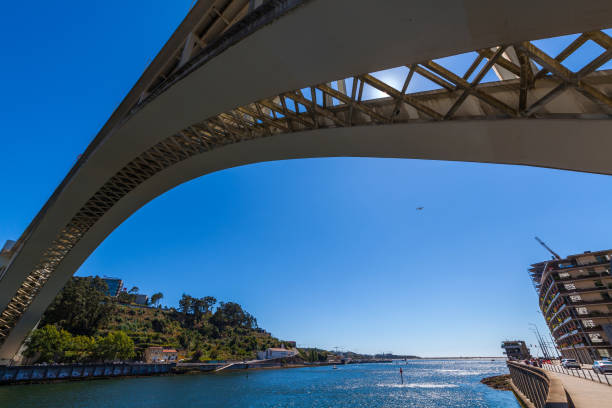 istock A striking architectural scene featuring a large, modern concrete arch bridge spanning across a wide river under a vibrant blue sky 2175328552
