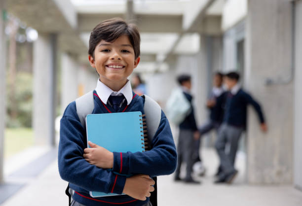 istock Happy boy smiling at school holding his notebook 2175339372