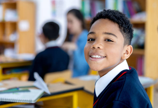 istock Happy boy in class at the school and looking at the camera smiling 2175339393