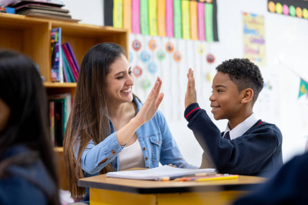 istock Happy teacher giving a high-five to a young student in class 2175339401