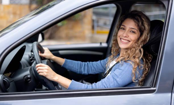 istock Happy woman driving her car and smiling 2175339418