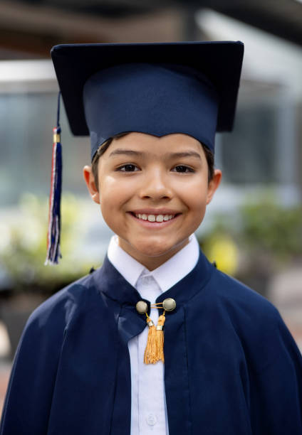 Portrait of a young student graduating from elementary school and looking at the camera smiling