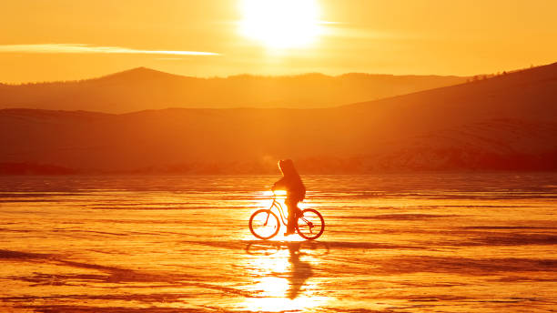 Cyclist at sunset on ice. Lake Baikal.