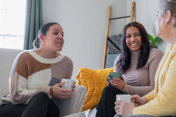 istock Seated together on the couch, three women enjoy their coffee and friendly conversation. 2175344593