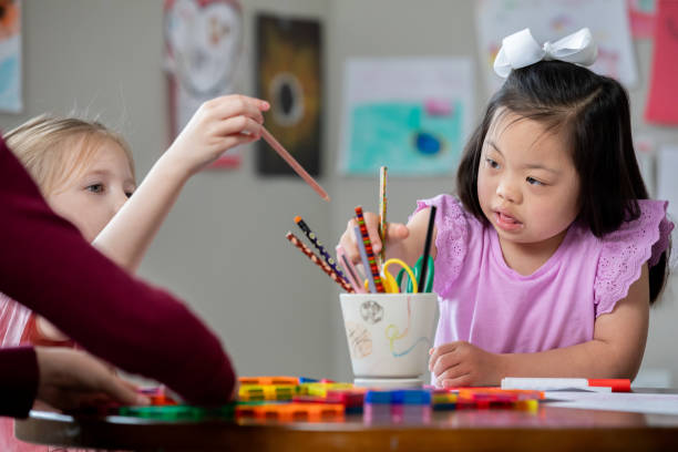 istock Special education student with Down Syndrome draws pictures with classmates 2175352710