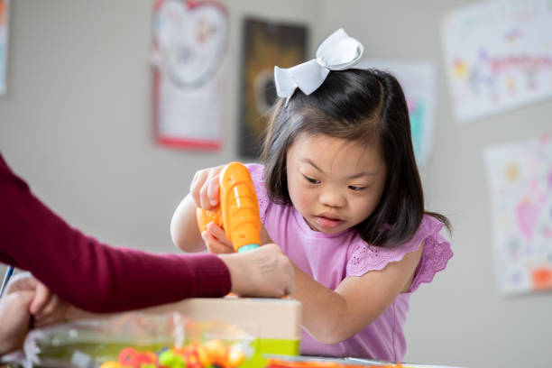 istock Little girl with Down Syndrome uses STEM building toy during elementary school class 2175352720