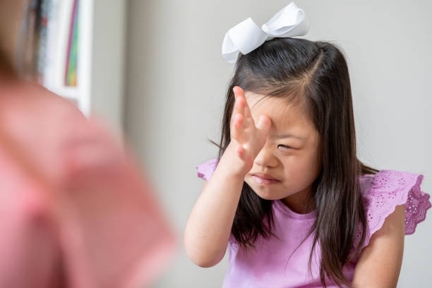 istock Child with Down Syndrome uses American Sign Language to communicate during special education class in elementary school 2175352730