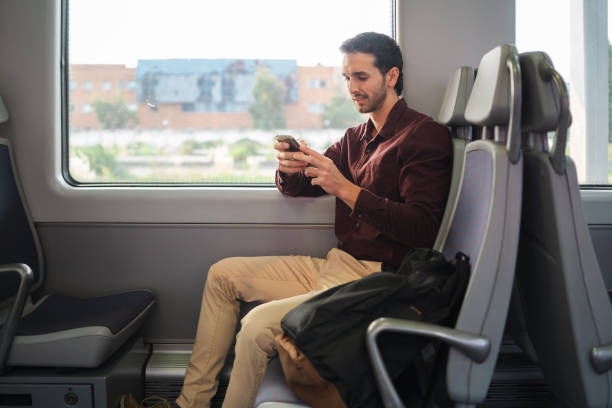 istock Young professional checks his phone while commuting to work on a train 2175357087