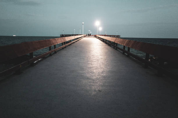 A long pier jutting out onto Lake Ontario at dusk.   The pier is located at the Toronto Islands.