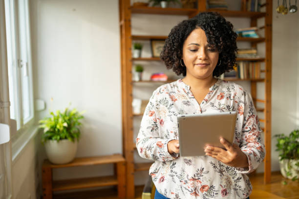 istock Smiling woman using digital tablet at home office 2175375923