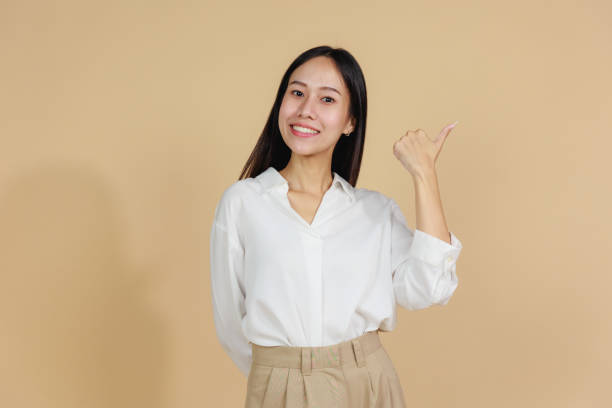 istock Smiling Woman Giving Thumbs Up, Beige Background 2175383350