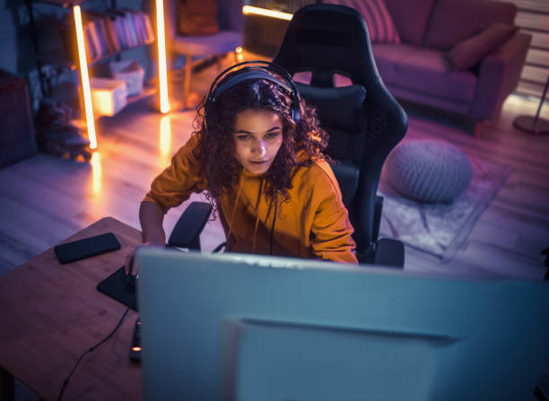 istock Young girl playing video games at home 2175383638