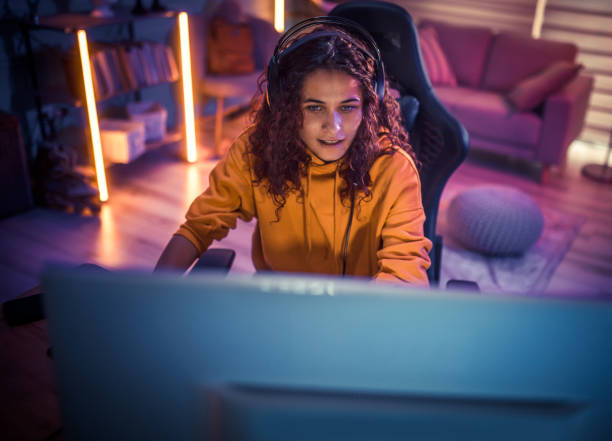 istock Young girl playing video games at home 2175383653