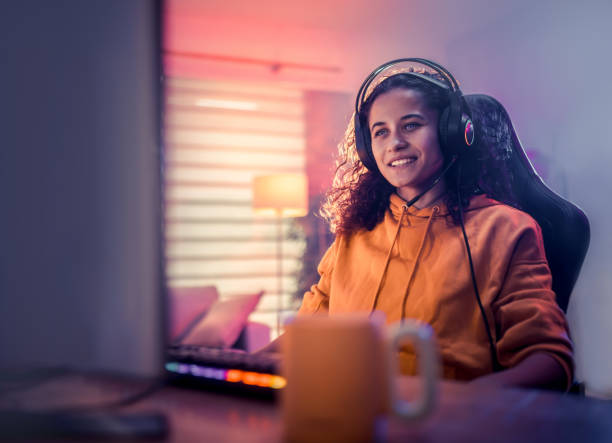 istock Young girl playing video games at home 2175383873