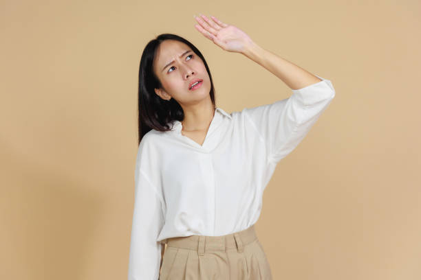 istock Overheated Woman Wiping Sweat from Forehead, Beige Background 2175383931